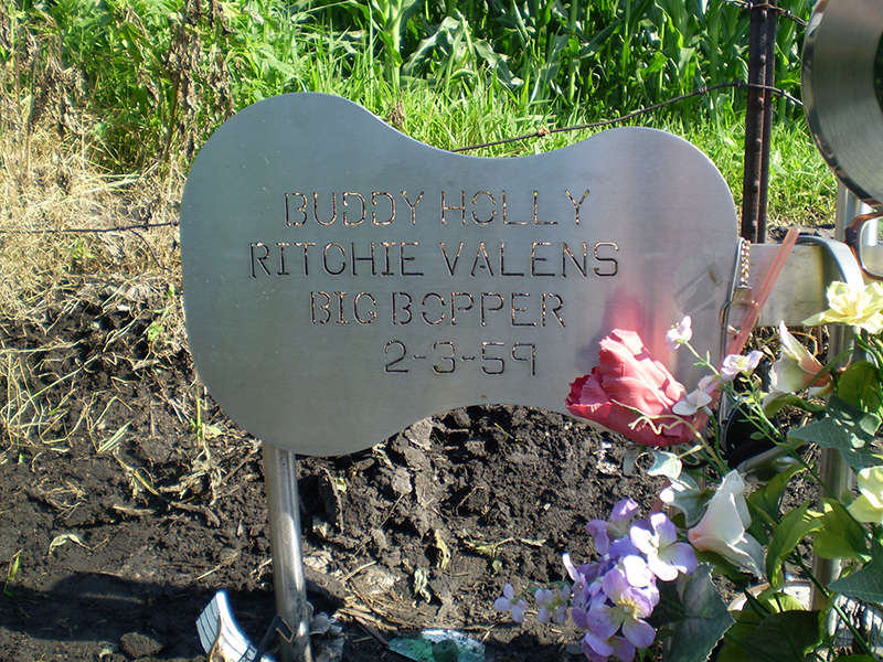 A closeup of the three rock stars names on a welded metal guitar 